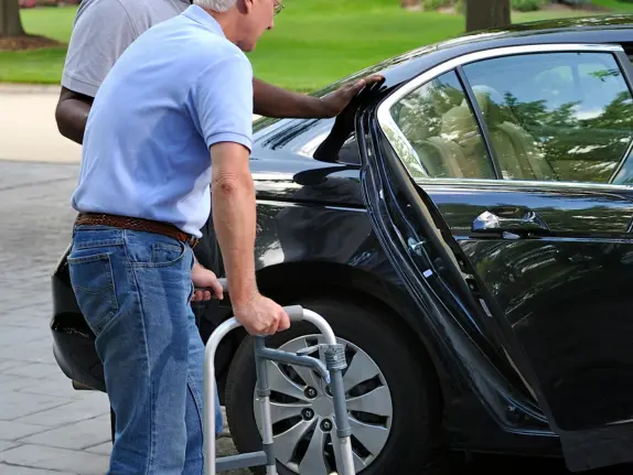 Passenger using a walker near a vehicle